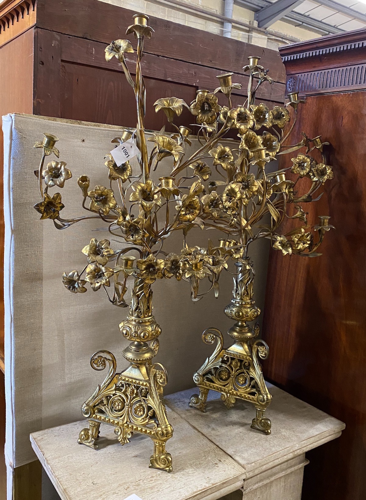 A pair of French gilt brass candelabra with flowering branches and ecclesiastical bases, height 99cm